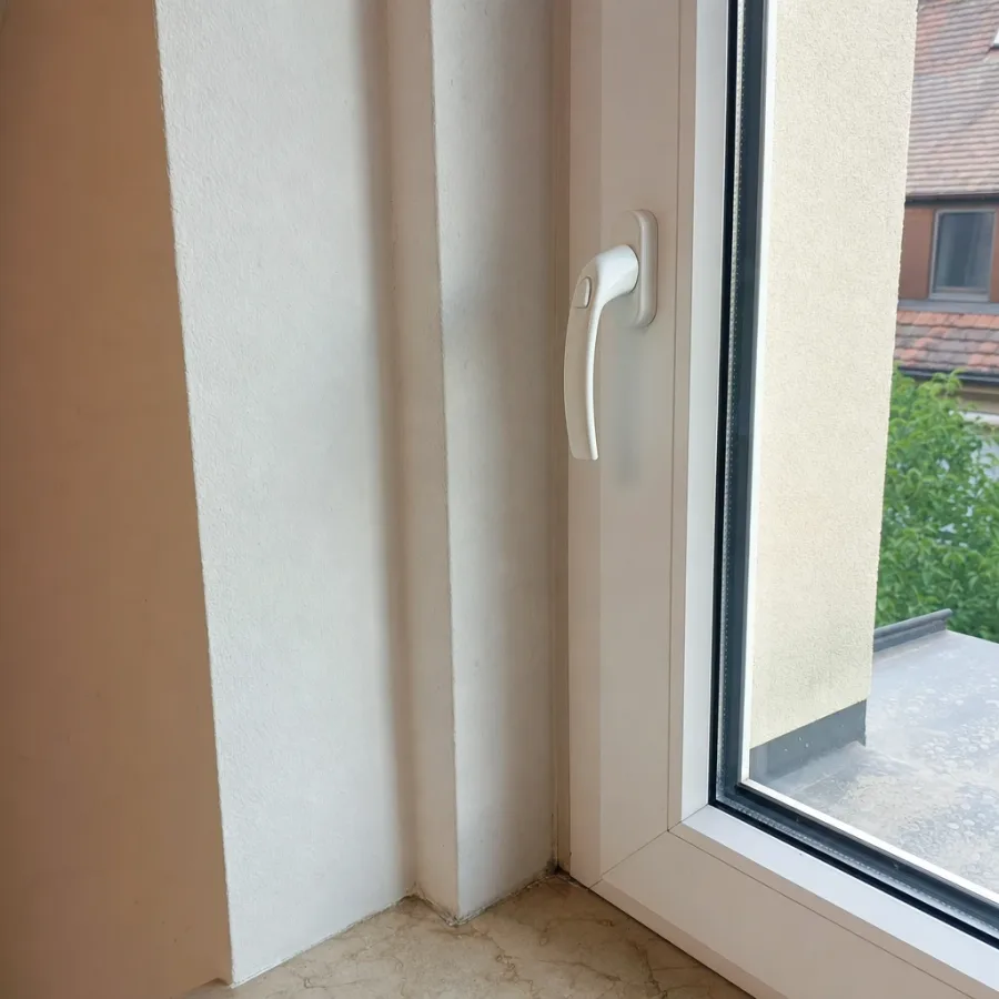 Handyfoto eines Kunststofffensters mit Rahmenprofil und Griff von innen