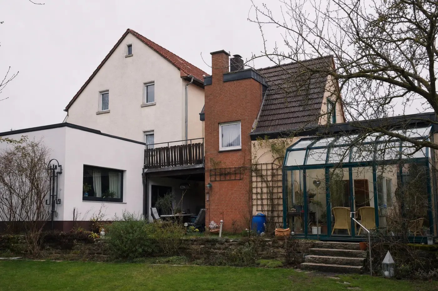 Gewachsenes Wohnhaus mit Anbauten aus mehreren Jahrzehnten, Flachdach-Erweiterung und Wintergarten