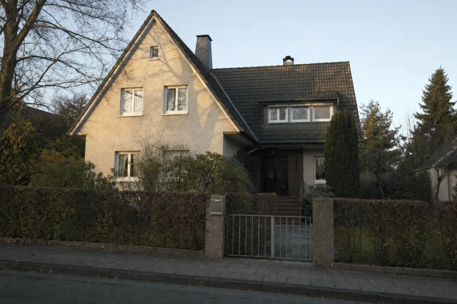 Gepflegtes Einfamilienhaus mit Gartenzaun und Briefkasten im Nachmittagslicht